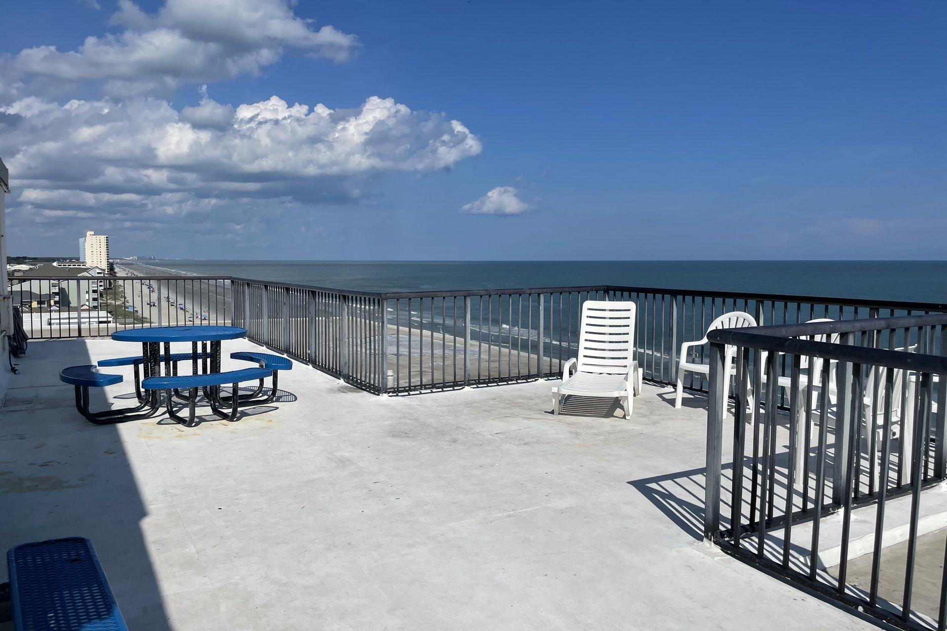Rooftop sun deck with lounge seating and Garden City beach views